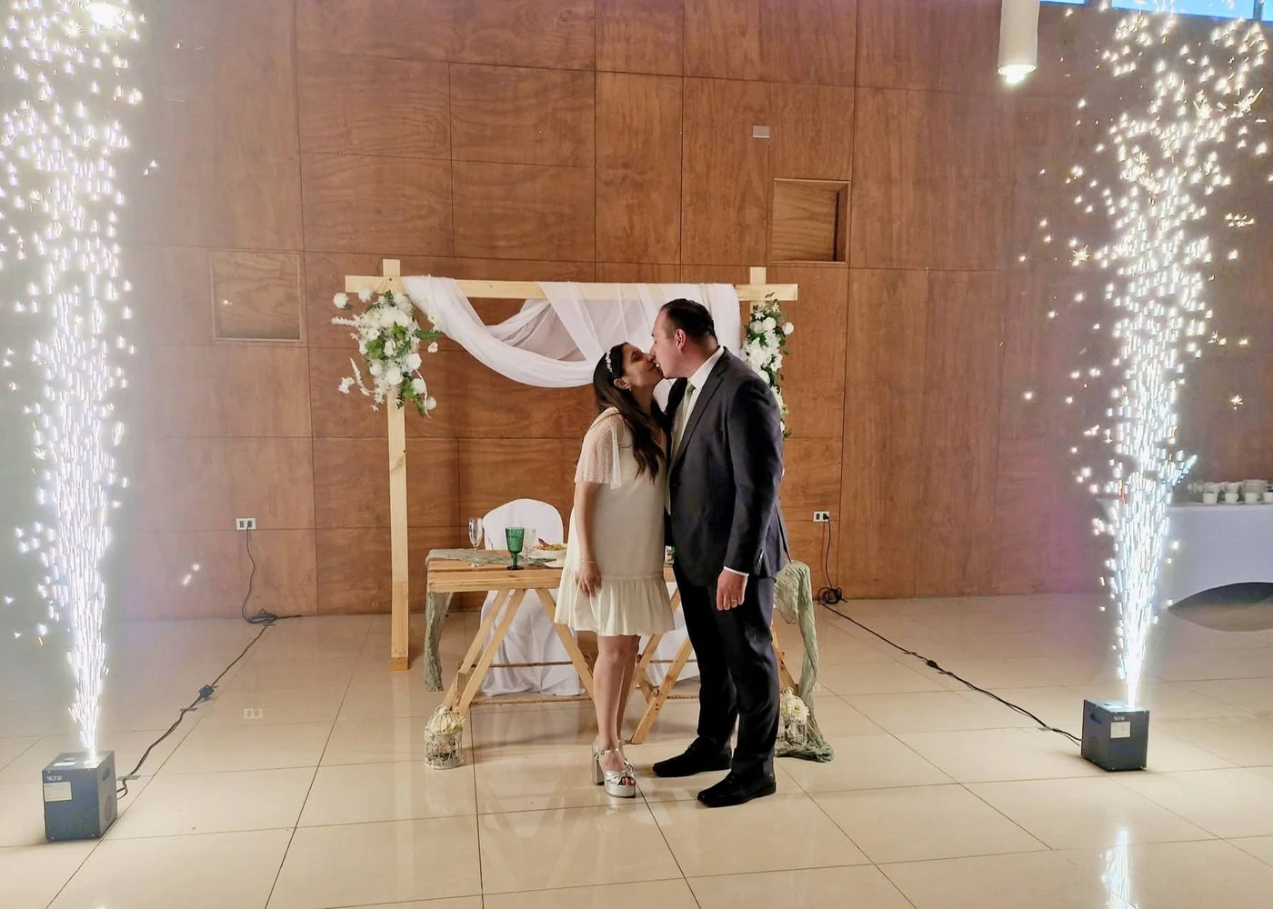 Pareja rodeada por dos columnas de chispas frías durante una celebración en Angol